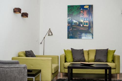 a living room with two yellow couches and a table at Apartments Blaickner in Neukirchen am Großvenediger
