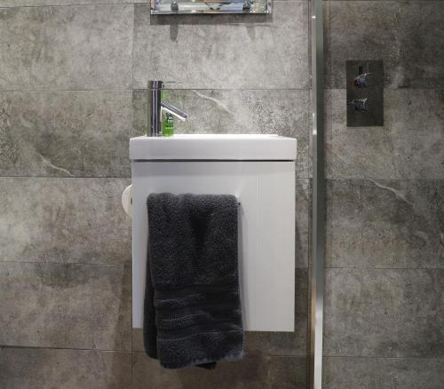 un baño con una toalla negra en la parte trasera de un aseo en Wimpenny Place, en Holmfirth