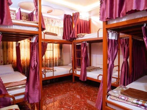ドン・ヴァンにあるAncient Town 29 Phố Cổの紫色のカーテンが付いた二段ベッド4台が備わる客室です。