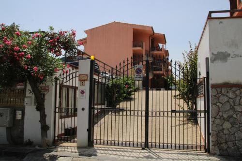 a gate in front of a building with flowers at Poseidone Sea Apartment Taormina in Mazzeo