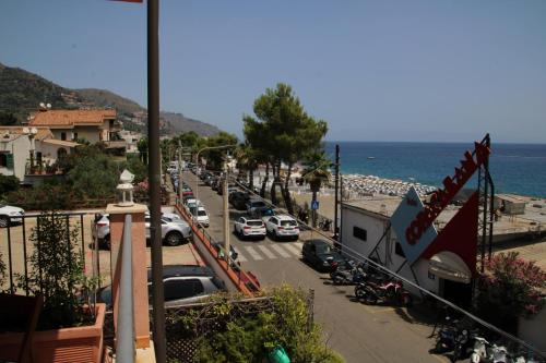 a view of a street with cars parked on a beach at Poseidone Sea Apartment Taormina in Mazzeo