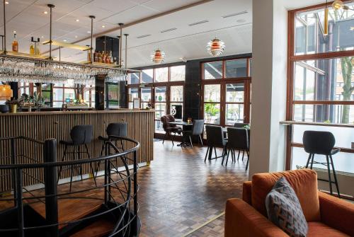 um restaurante com um bar com cadeiras e mesas em Hotel Medi em Ikast