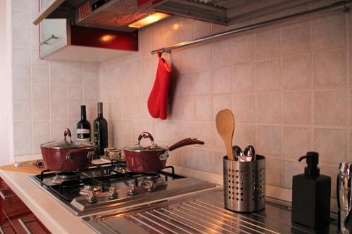 two pots on a stove in a kitchen at Poseidone Sea Apartment Taormina in Mazzeo