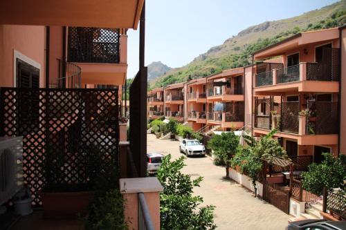 an apartment complex with cars parked in a parking lot at Poseidone Sea Apartment Taormina in Mazzeo