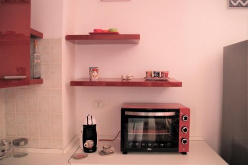 a red microwave sitting on top of a kitchen counter at Poseidone Sea Apartment Taormina in Mazzeo