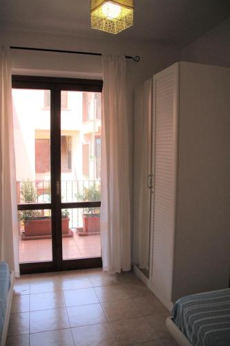a bedroom with a sliding glass door to a balcony at Poseidone Sea Apartment Taormina in Mazzeo