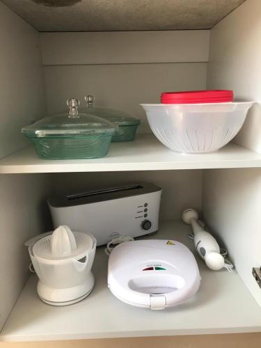 a shelf with bowls and other kitchen items on it at Sweet Love Family I in Coimbra