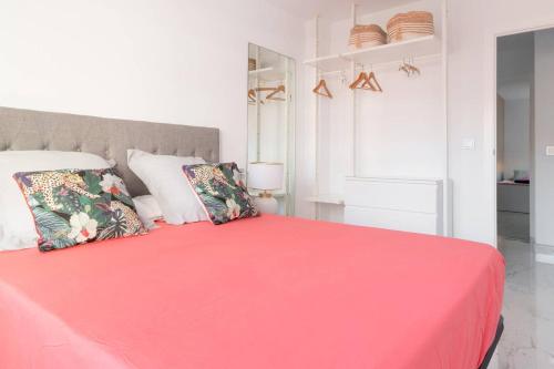 a bedroom with a pink bed with two pillows at Apartamento Puertoplaya II in Puerto de Mazarrón