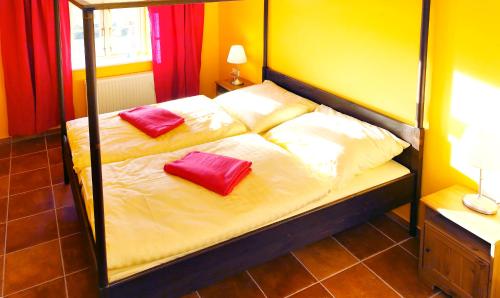 a bed with two red pillows on top of it at Vogelhaus Gobbin in Lancken-Granitz