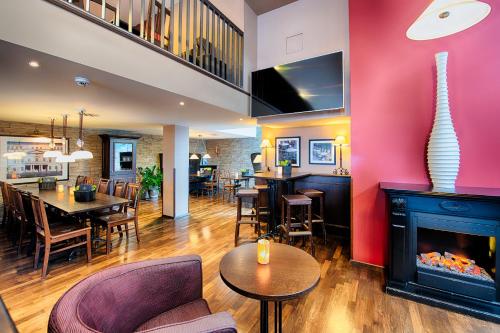 a living room with a fireplace and a dining room at Welcome Hotel Darmstadt City Center in Darmstadt