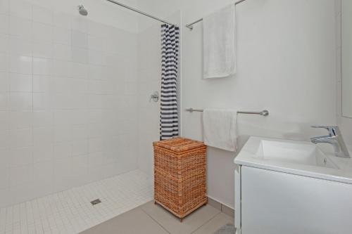 uma casa de banho branca com um chuveiro e um lavatório. em Views Views Views em Hermanus