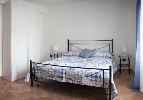 ein Schlafzimmer mit einem Bett mit einer blau-weißen Bettdecke in der Unterkunft La Casa di Anna in Castellabate