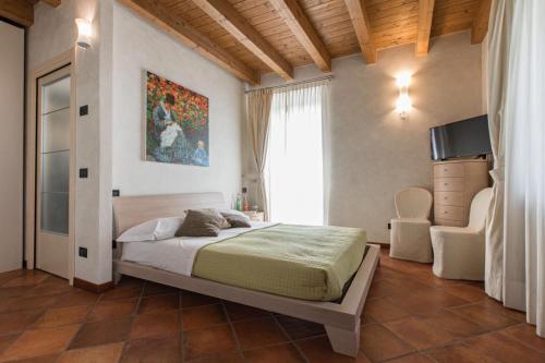 1 dormitorio con 1 cama, TV y ventana en Fontanile Relais - Valcalepio Lounge en Gandosso