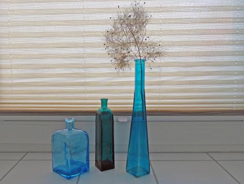 three blue vases sitting on a table with a window at Ferienwohnung am Wall in Soest