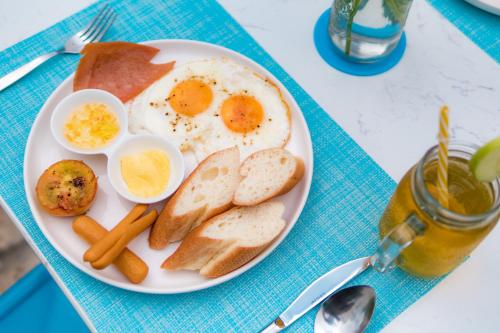 un plato de huevos, pan y tostadas en una mesa en Glow Inn Siem Reap, en Siem Reap