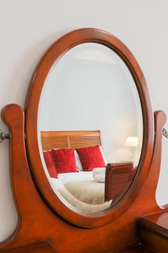 a mirror with a wooden frame in a bedroom at The Clee Hotel - Cleethorpes, Grimsby, Lincolnshire in Cleethorpes