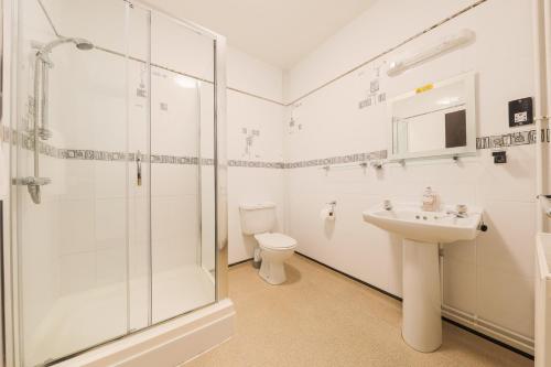 a bathroom with a shower and a sink and a toilet at The Clee Hotel - Cleethorpes, Grimsby, Lincolnshire in Cleethorpes