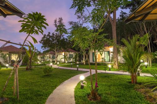 Aonang Eco Villa - SHA Extra Plus في شاطيء آونانغ: ممشى من خلال حديقة في الليل