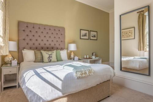 a bedroom with a large bed with a large mirror at The Sun Inn in Faversham