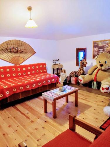 a living room with a red couch and stuffed animals at Villa Annoula in Pouríon