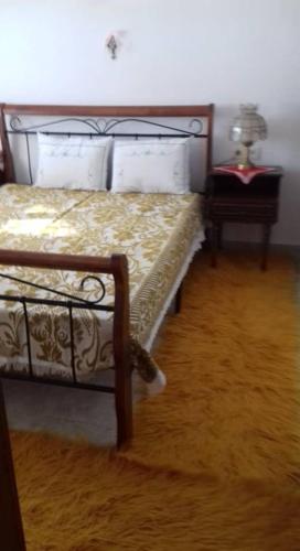 a bedroom with a bed and a table with a lamp at Villa Annoula in Pouríon