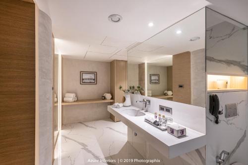 a bathroom with a sink and a large mirror at Clarks Inn Suites Raipur in Raipur