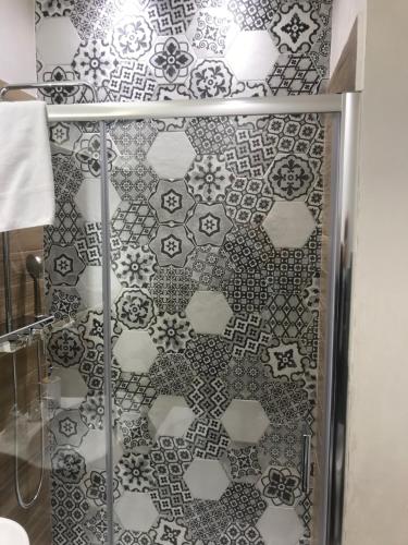 a bathroom with a shower with a tiled wall at MiraMonti Rooms in Campobasso