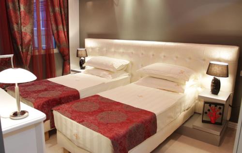 two beds in a hotel room with two lamps at Hotel Boutique Vila Fernando Tirana in Tirana