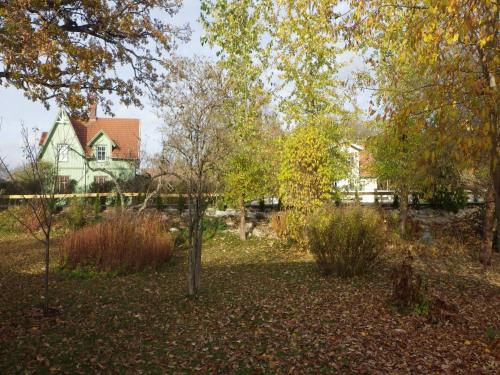 a yard with trees and a house in the background at Bergsvägen Bed & Breakfast in Urshult