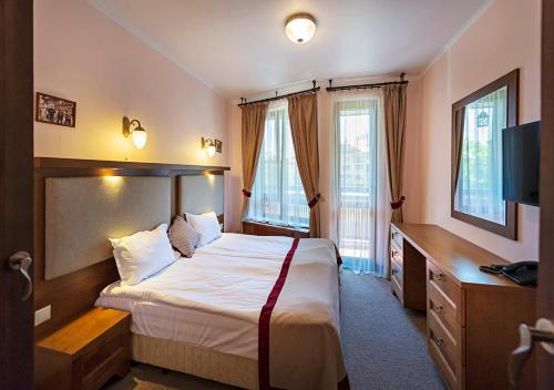a hotel room with a bed and a television at 7 Pools SPA Boutique Hotel in Bansko
