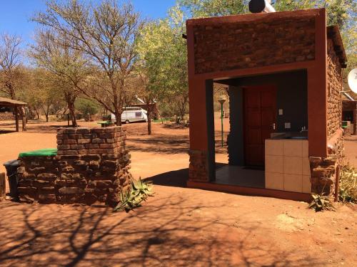 a building with a stone wall and a doorway at Red Sands Country Lodge in Kuruman