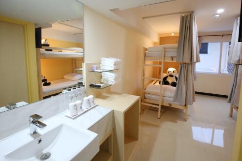 a bathroom with a sink and a room with bunk beds at Lucky panda Hotel in Chiang Mai