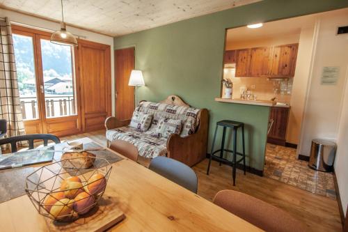 a kitchen and living room with a table and a couch at Appartements Giffre et Clesson - DAHU COMPAGNIE in Samoëns