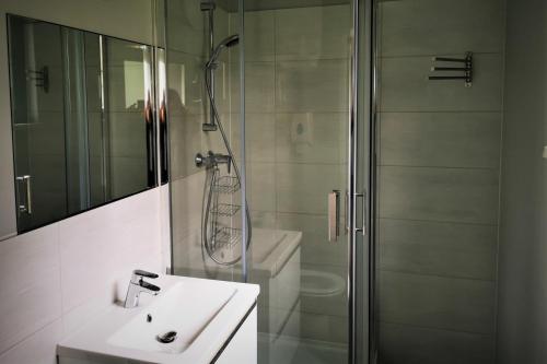 a bathroom with a shower and a sink and a shower at Centrum Żeglarskie Domki Kempingowe in Szczecin