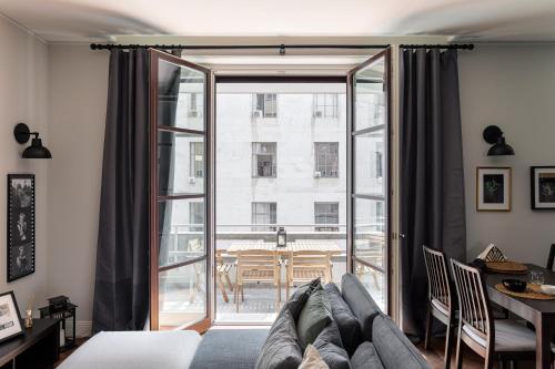 salon z kanapą i dużym oknem w obiekcie Wide and Bright two bedroom apartment w Mediolanie