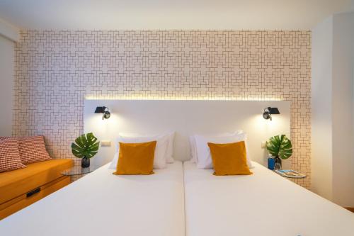 a bedroom with a large white bed with yellow pillows at Hotel Cetina Murcia in Murcia
