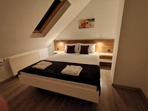 a bedroom with a bed with two towels on it at Niš City Center Guest House in Niš