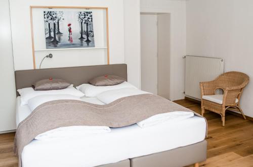 two beds in a room with a chair at Apartments Blaickner in Neukirchen am Großvenediger
