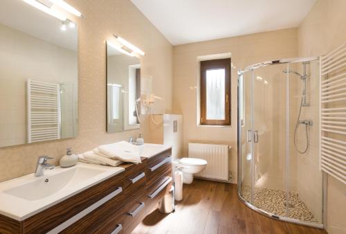 a bathroom with a sink and a shower and a toilet at Harangvirág Apartmanház - Visegrád in Visegrád