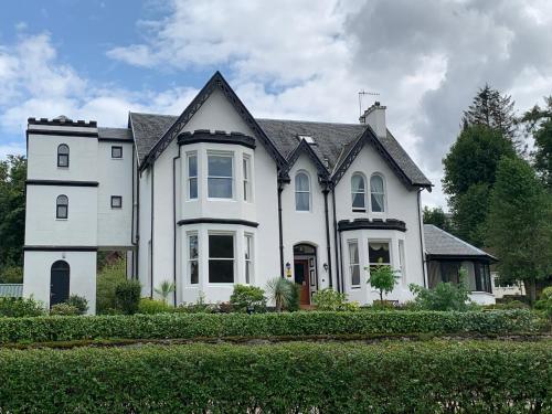 a white house with a black roof at Ashburn House in Fort William