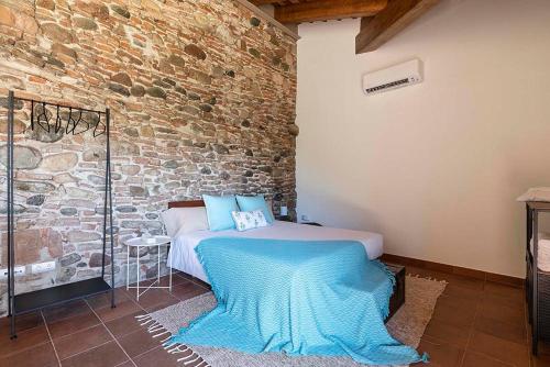 a bedroom with a bed and a brick wall at RUSTIC & CHIC b&b in Granollers