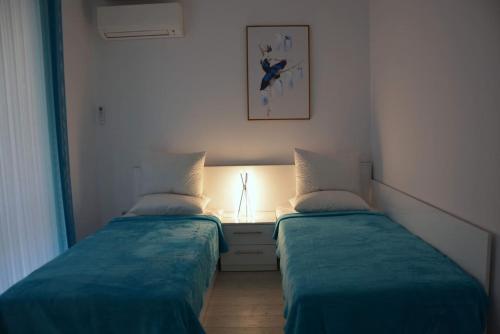 two beds in a room with a light between them at Unbeatable Location: New Lux Apartment Varna beach in Varna City