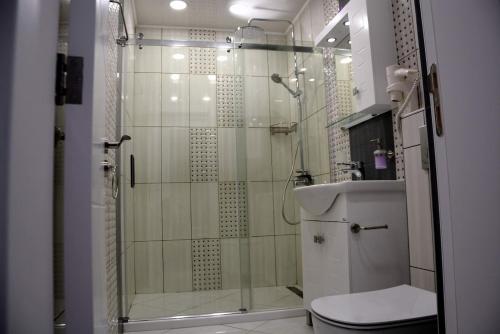 y baño con ducha, aseo y lavamanos. en Unbeatable Location: New Lux Apartment Varna beach, en Varna