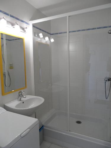 une salle de bain blanche avec une douche et un lavabo dans l'établissement REF 204 Appartement pour six personnes situé entre port Crouesty et la plage ARZON, à Arzon