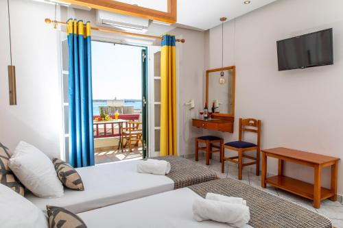 a living room with two beds and a balcony at Hotel Palatia in Naxos Chora