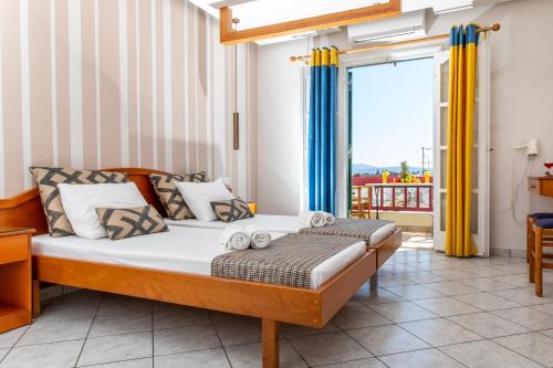a bedroom with a bed and a balcony at Hotel Palatia in Naxos Chora