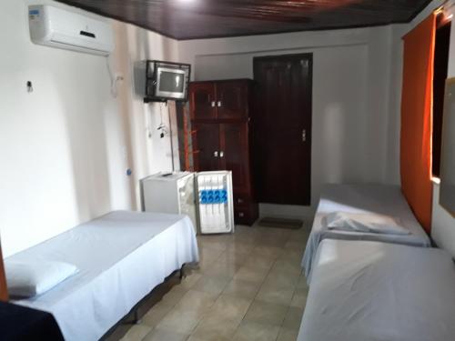 a hotel room with two beds and a tv at Vera's Apart Hotel in Belém