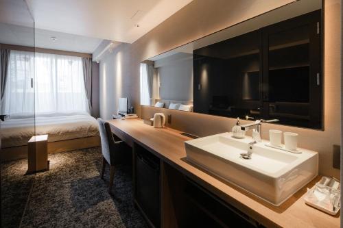 a bathroom with a sink and a large mirror at MATERIAL Fuchomae in Kyoto