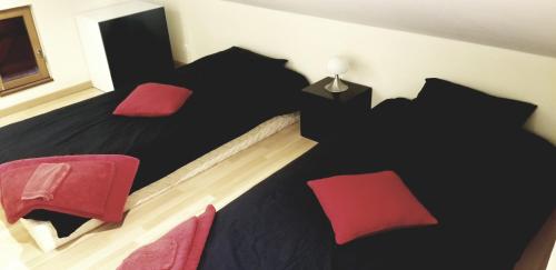 a bedroom with a black bed and red chairs at Gîte Coeur de Lorraine in Manoncourt sur Seille-Belleau