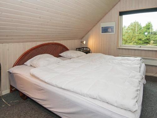 ein großes weißes Bett in einem Zimmer mit Fenster in der Unterkunft 4 star holiday home in Rømø in Mølby